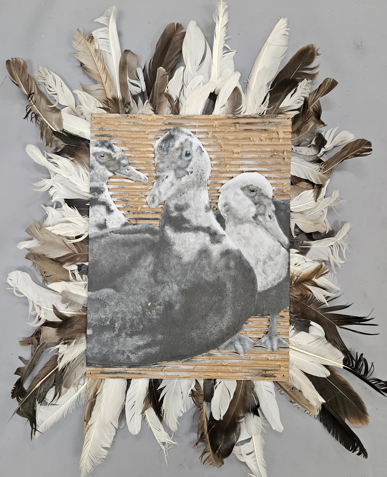 Mixed-media duck piece surrounded by real feathers.